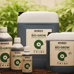 Bottiglie e taniche di fertilizzante BIOBIZZ BIO-GROW in un ambiente con piante verdi. Un light mix per la crescita.