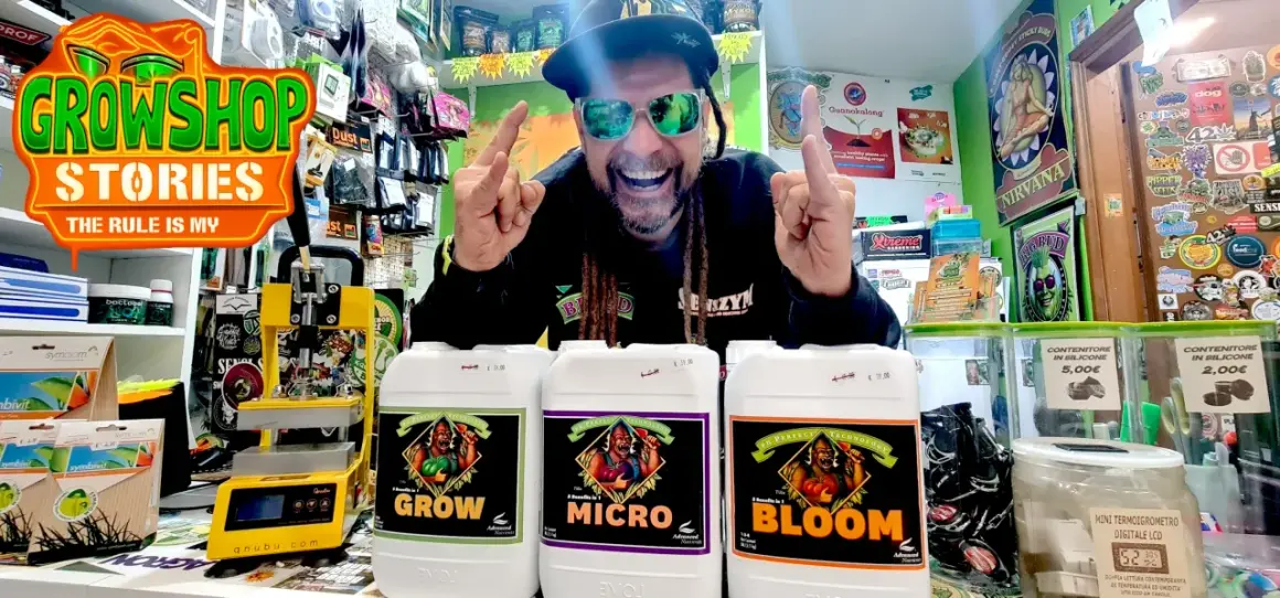 Uomo sorridente con occhiali da sole mostra flaconi di fertilizzanti Advanced Nutrients per la crescita, micro e fioritura.